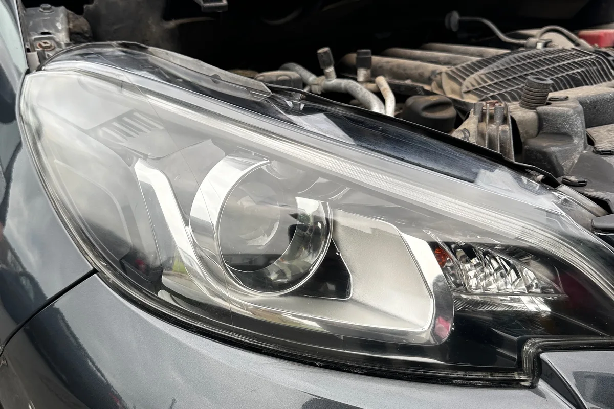 After: Headlight restoration by JJ Valets on a grey Peugeot: cloudy, scratched headlight before and crystal clear after, Bognor Regis